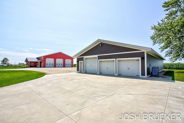 view of side of home with a garage, a yard, and an outbuilding