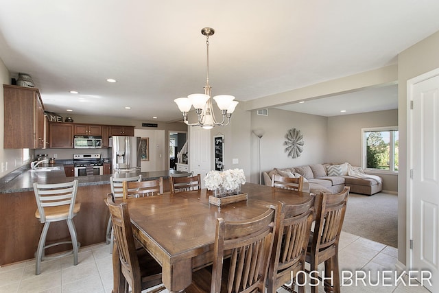 dining room with sink, light tile patterned floors, and a chandelier