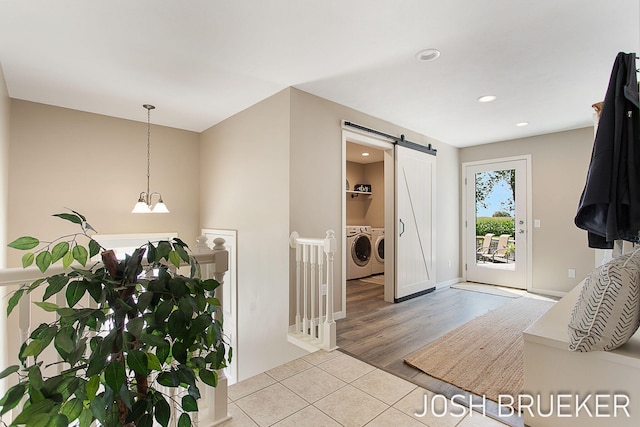 foyer entrance with light tile patterned floors, independent washer and dryer, and a barn door