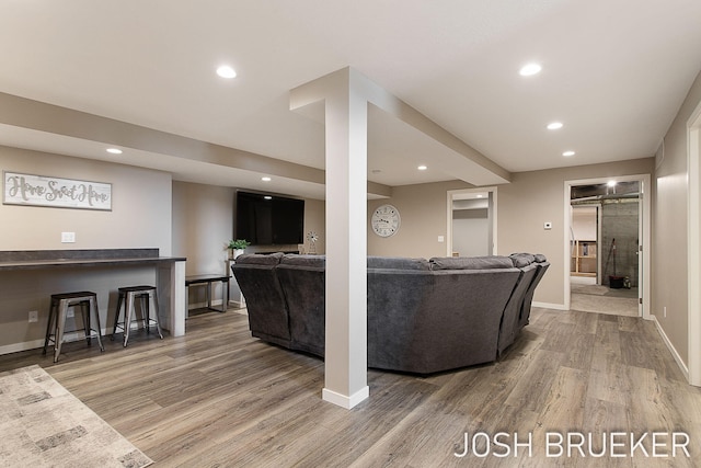 living room with hardwood / wood-style floors and bar area