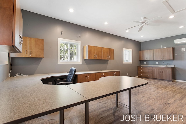 kitchen featuring light hardwood / wood-style flooring, sink, built in desk, and a healthy amount of sunlight