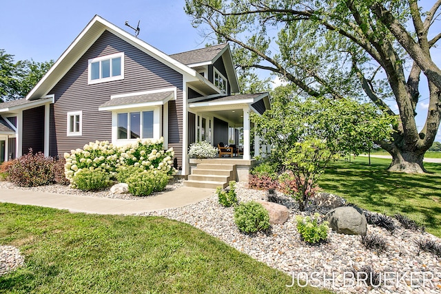 view of front of home with covered porch and a front yard