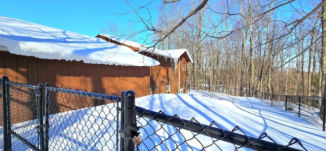 yard covered in snow featuring fence and a gate