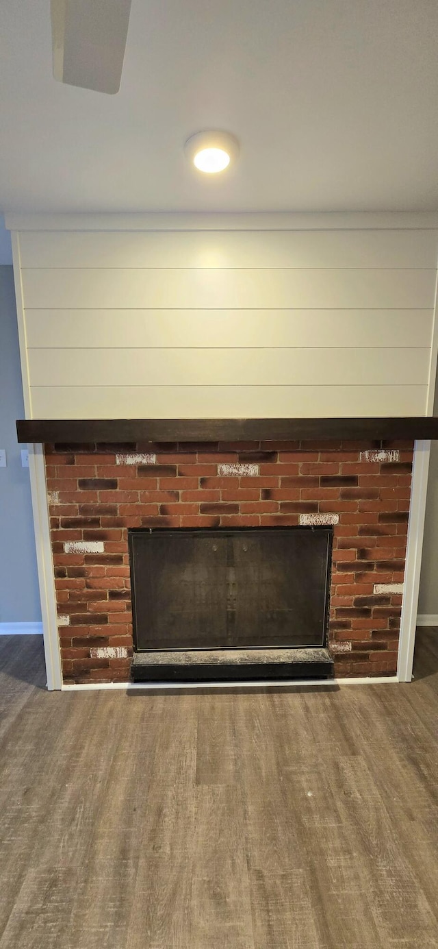 interior details with a fireplace, wood finished floors, and baseboards