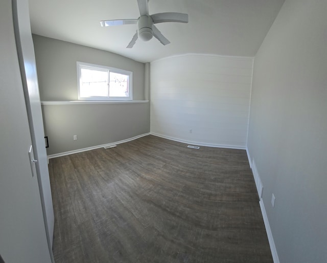 unfurnished room featuring dark wood-style floors, a ceiling fan, and baseboards