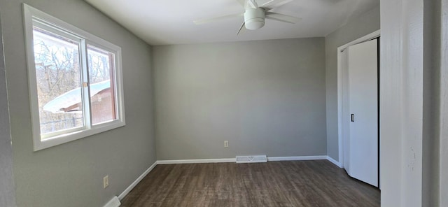 unfurnished bedroom featuring a closet, dark wood-style flooring, visible vents, and baseboards