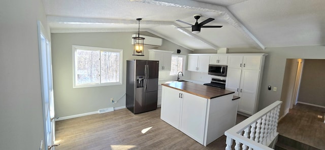 kitchen featuring visible vents, wooden counters, appliances with stainless steel finishes, a sink, and wood finished floors