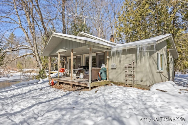 view of snow covered back of property