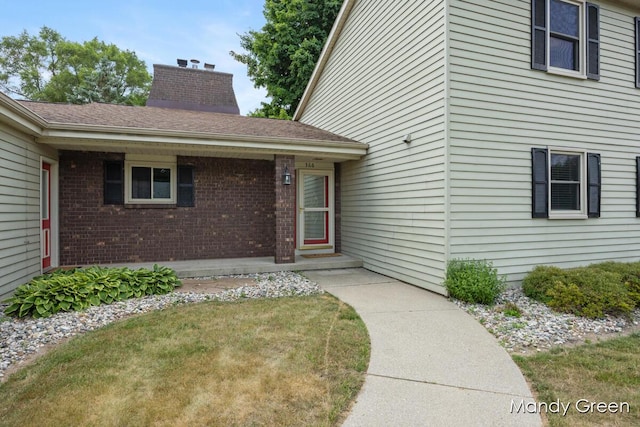 366 E Beech St NE, Cedar Springs, MI 49319 - entrance to property with brick siding, a chimney, and a lawn