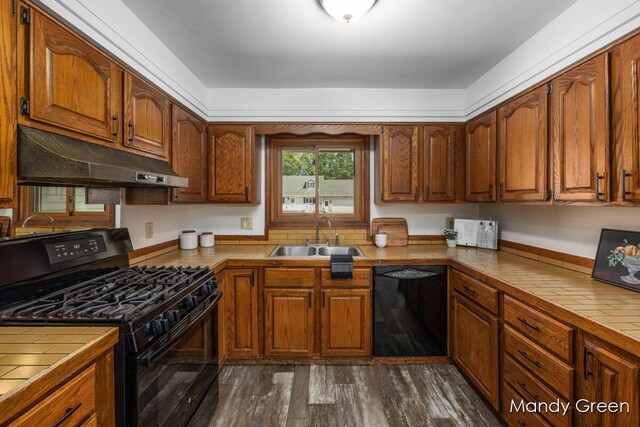 366 E Beech St NE, Cedar Springs, MI 49319 - kitchen with black appliances, tile counters, under cabinet range hood, and brown cabinets