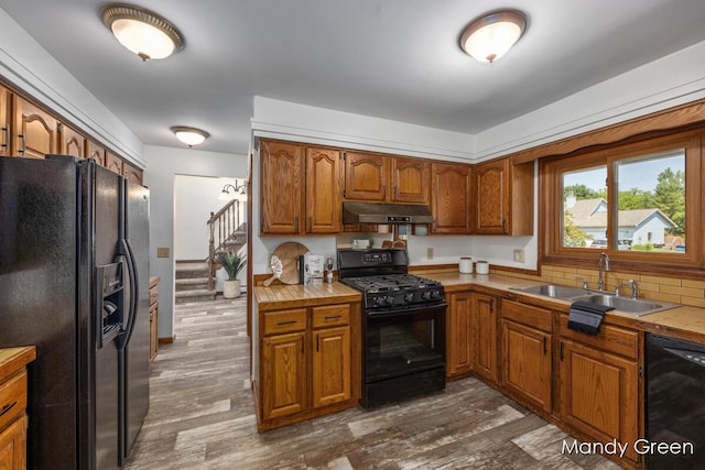 366 E Beech St NE, Cedar Springs, MI 49319 - kitchen featuring black appliances, under cabinet range hood, brown cabinets, and dark wood-style floors