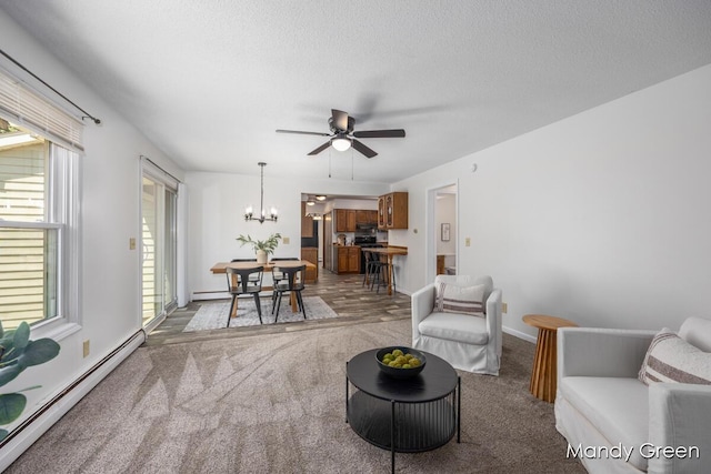 366 E Beech St NE, Cedar Springs, MI 49319 - living area with a baseboard radiator, a ceiling fan, a chandelier, carpet, and a textured ceiling