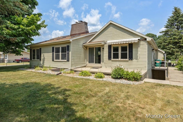 366 E Beech St NE, Cedar Springs, MI 49319 - rear view of house featuring a chimney and a lawn