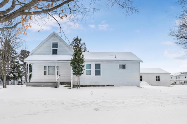 view of snow covered back of property