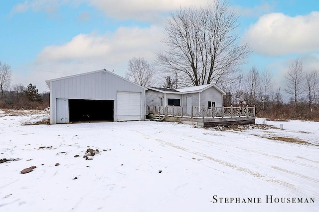 view of front of house featuring an outbuilding, a garage, and a deck