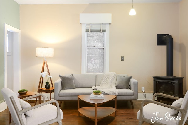 living room with dark hardwood / wood-style floors and a wood stove