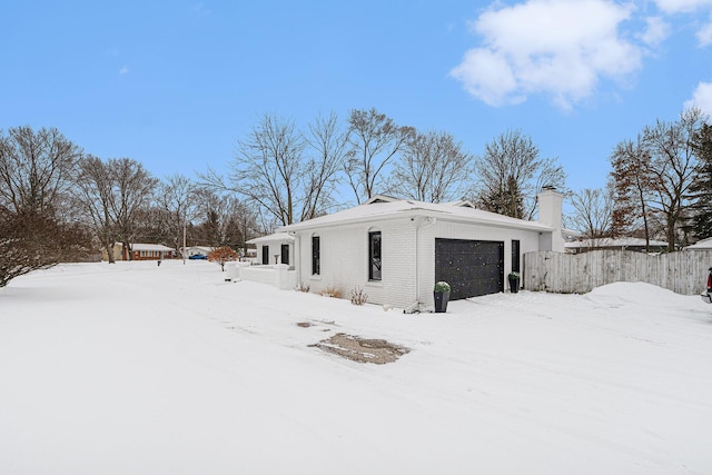 view of snowy exterior with brick siding