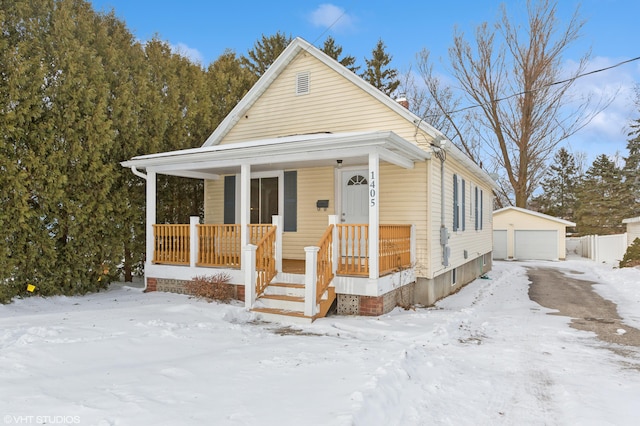 bungalow featuring a porch, an outdoor structure, and a garage