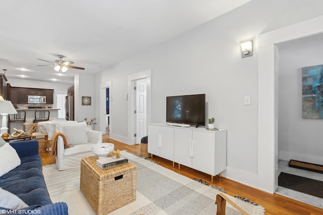 living room with ceiling fan and light hardwood / wood-style floors