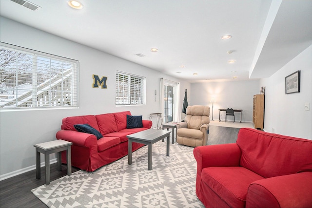 living area with recessed lighting, visible vents, baseboards, and wood finished floors