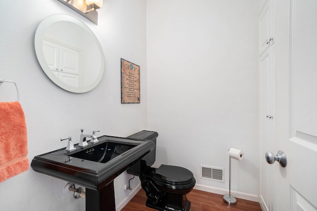 bathroom with visible vents, baseboards, toilet, and wood finished floors