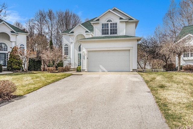 traditional-style house with driveway, a front yard, and a garage
