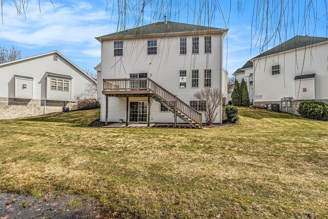 rear view of property with a yard, a wooden deck, cooling unit, and stairs