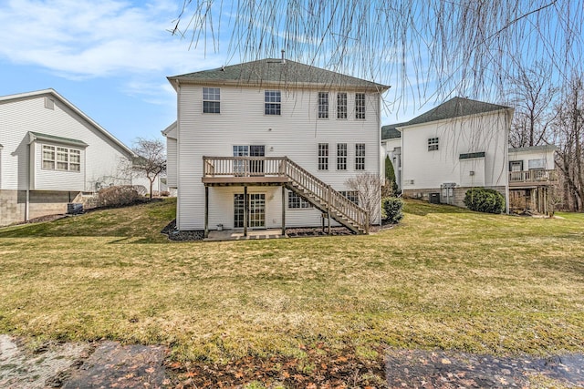 back of property with stairway, a wooden deck, and a yard