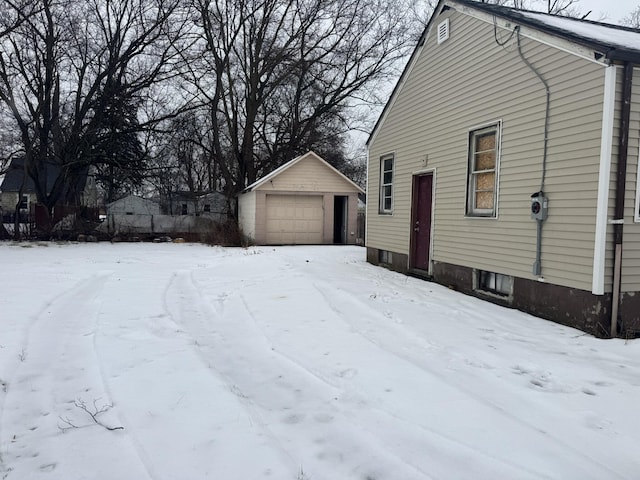 snow covered property with an outbuilding and a garage