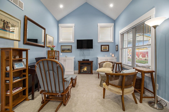 sitting room with light carpet, visible vents, high vaulted ceiling, and a wealth of natural light