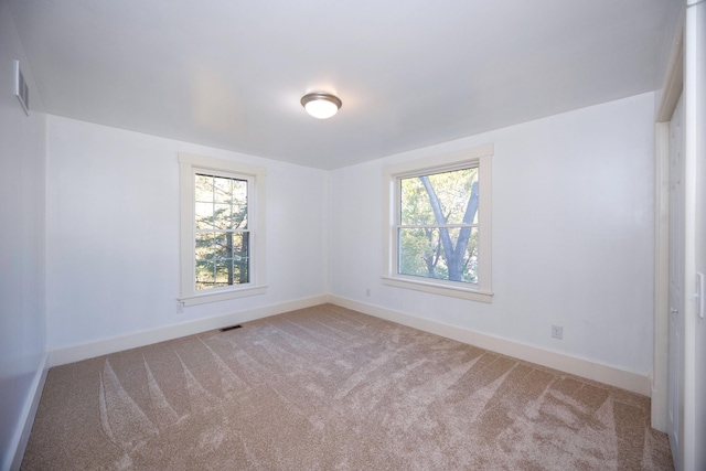 unfurnished room with a wealth of natural light and light colored carpet