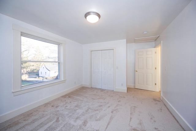 unfurnished bedroom with a closet and light carpet