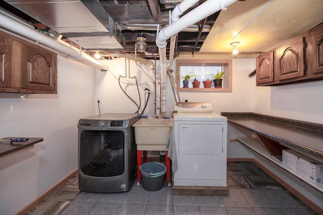 washroom with sink, washer and clothes dryer, and cabinets