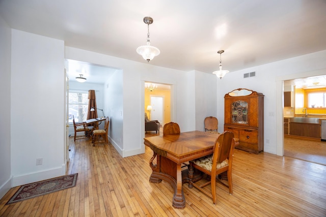 dining space with plenty of natural light, sink, and light hardwood / wood-style floors