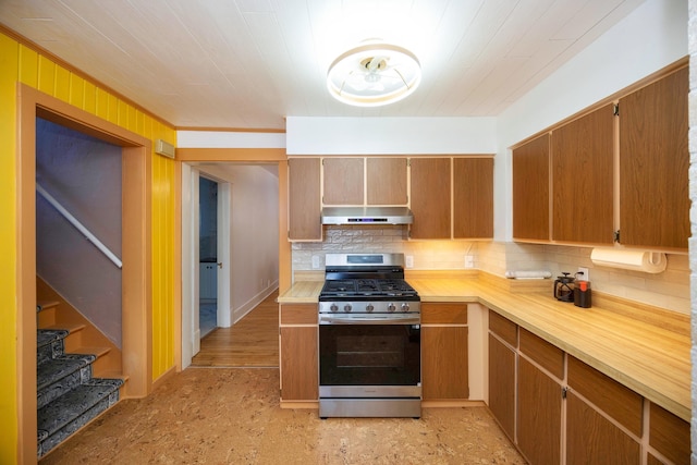 kitchen featuring stainless steel gas stove and tasteful backsplash