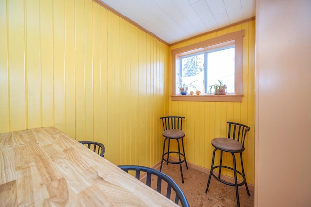 interior space with crown molding and wood walls