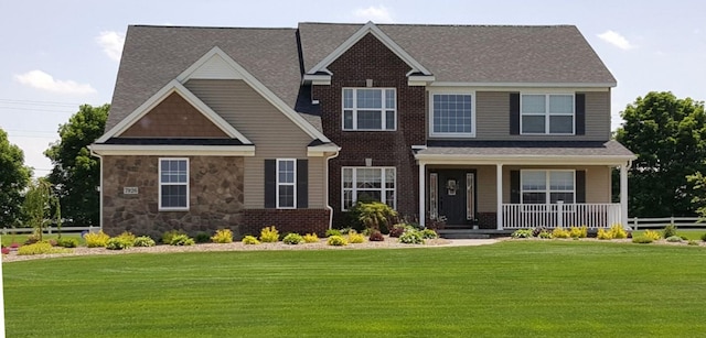 craftsman inspired home with a front yard and covered porch