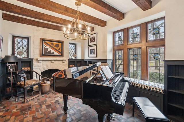 sitting room featuring a premium fireplace, brick floor, beamed ceiling, and a notable chandelier