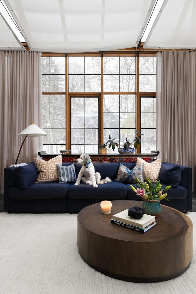 living room featuring beamed ceiling, floor to ceiling windows, and a wealth of natural light