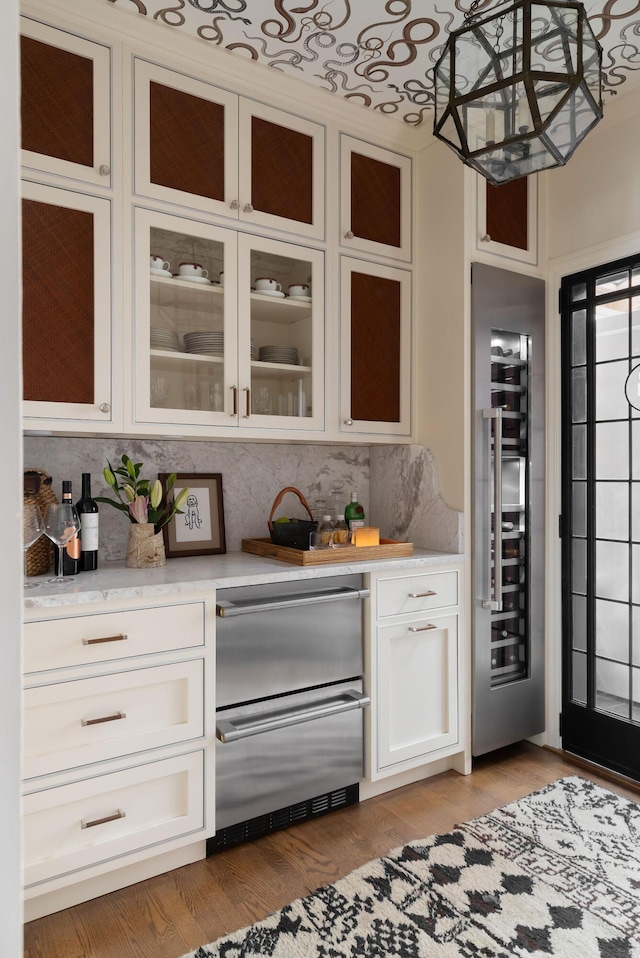 bar with tasteful backsplash, light wood finished floors, and wine cooler