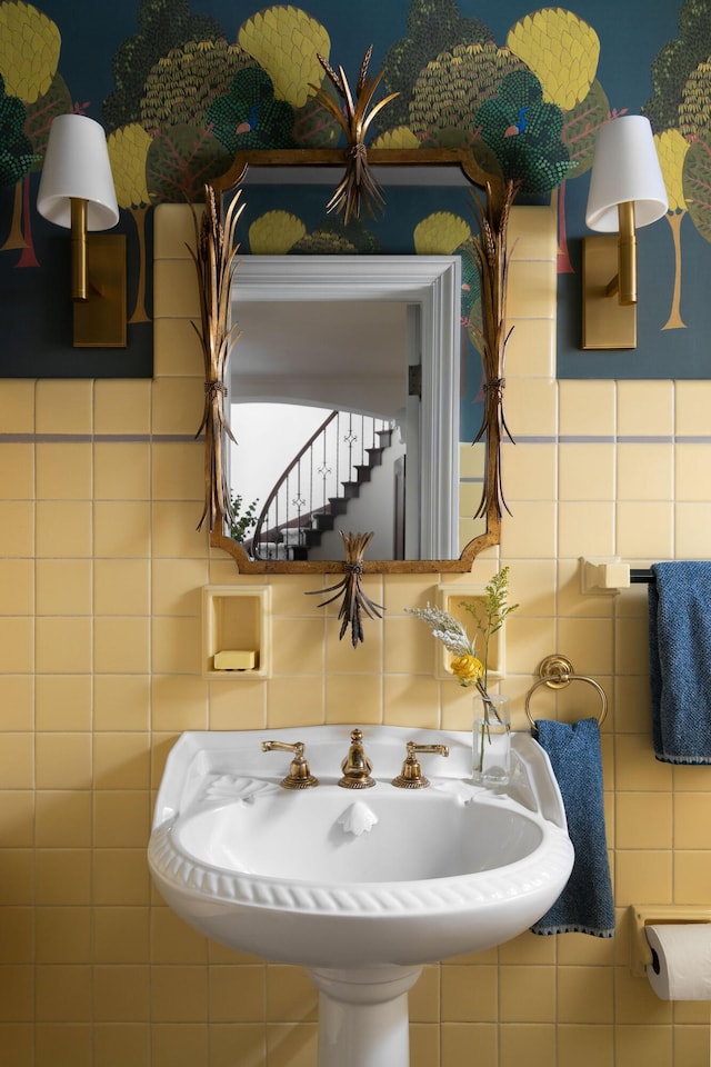 bathroom with a sink and tile walls