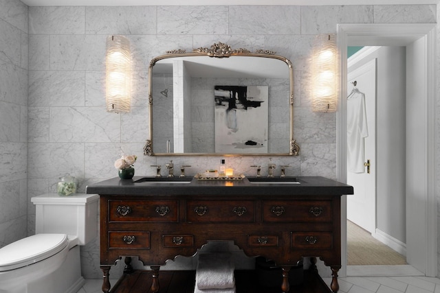 bathroom featuring double vanity, a sink, and toilet