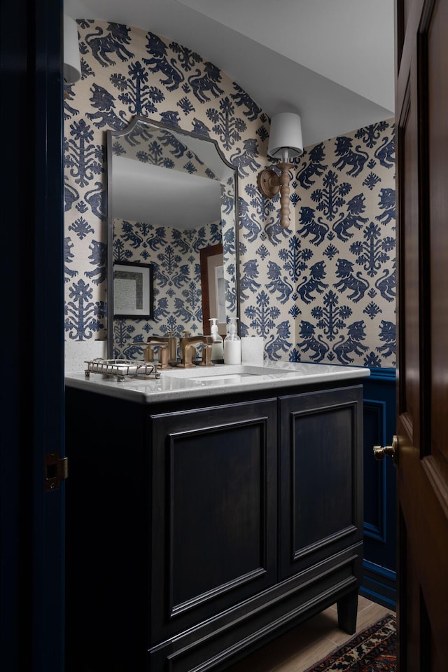 bathroom with wallpapered walls and vanity
