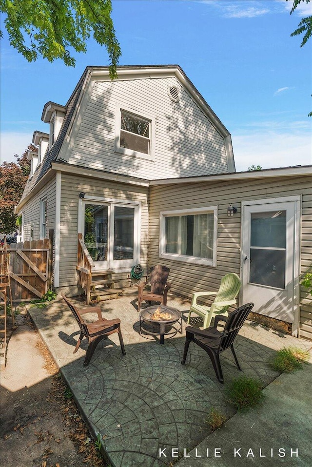 324 Gunnison Ave SW, Grand Rapids, MI 49504 - back of house featuring a gambrel roof, a fire pit, and a patio area