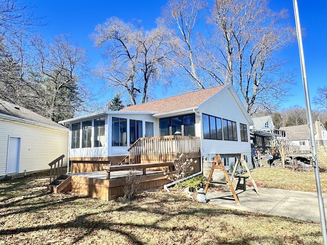 12118 N Sherman Lake Dr, Augusta, MI 49012 - back of house with a deck, a shingled roof, and a sunroom