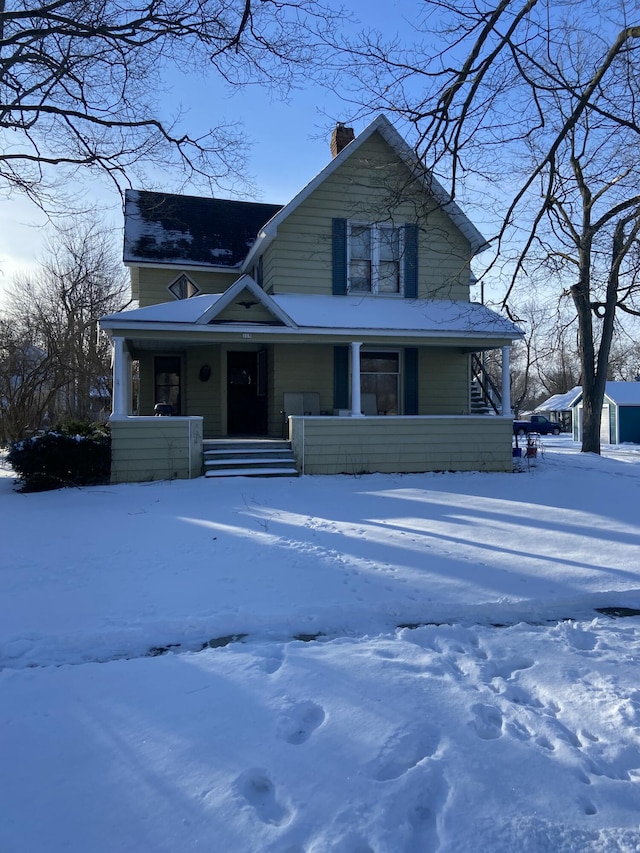 view of front facade with covered porch and a chimney