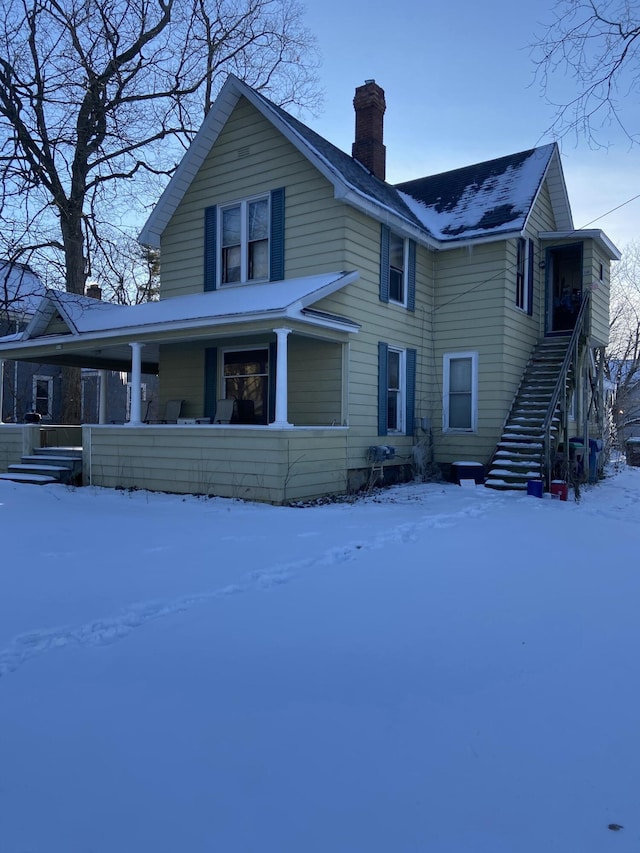 view of front facade featuring a porch and a chimney