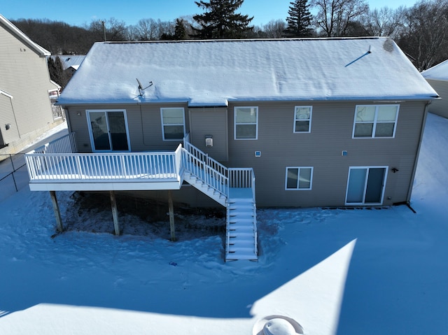 snow covered property featuring stairs and a wooden deck