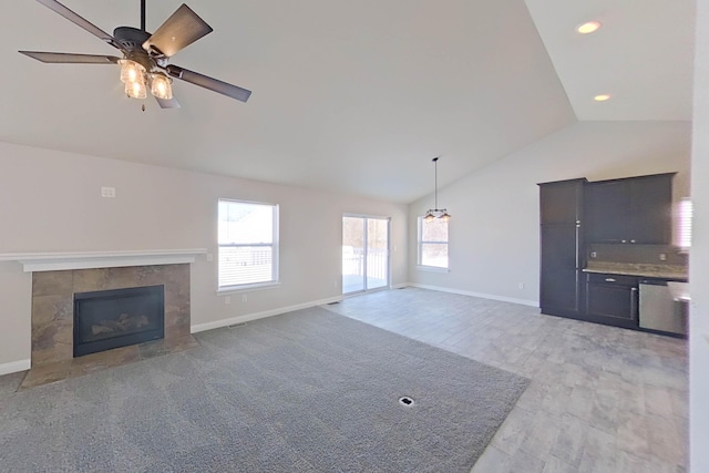 unfurnished living room with lofted ceiling, ceiling fan, a tile fireplace, recessed lighting, and baseboards