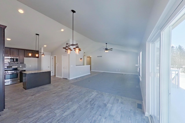 kitchen featuring light wood-style flooring, appliances with stainless steel finishes, a center island, dark brown cabinets, and ceiling fan with notable chandelier